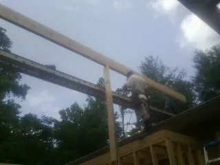 Carpenter setting a ridge beam over a new addition frame — Ice Dam Removal by Roofing Brothers in Stamford
