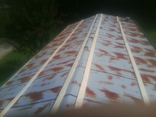 Rusted metal roof panels with new wood purlins before replacement — Storm Damage Roof Repair in Stamford by Roofing Brothers