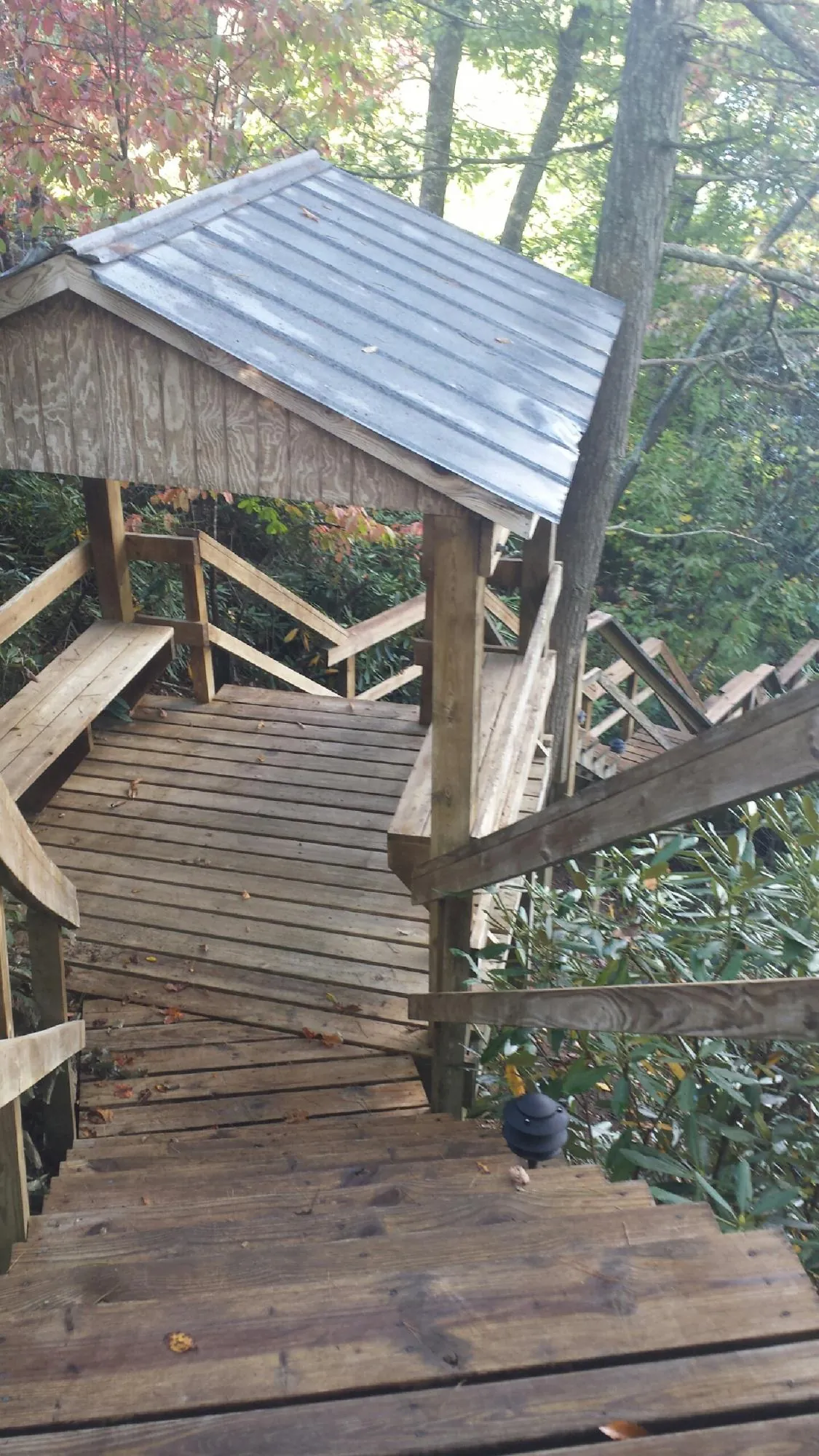 Metal roofed shelter over wooden steps on a wooded walkway — Skylight Repair & Installation work by our crew in Stamford