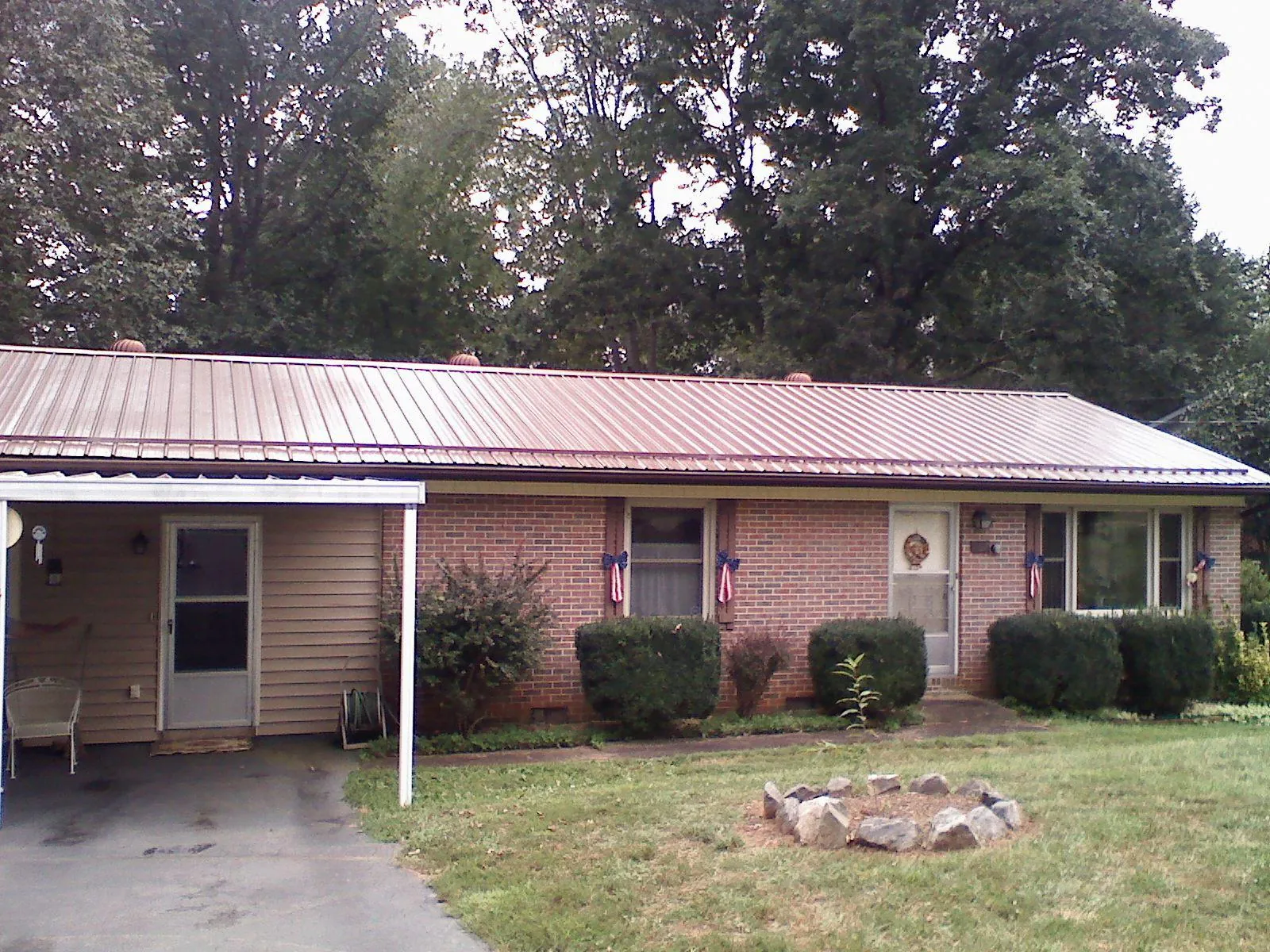 Bronze metal roof and carport on a brick ranch home — Roof Repair work by our crew in Stamford
